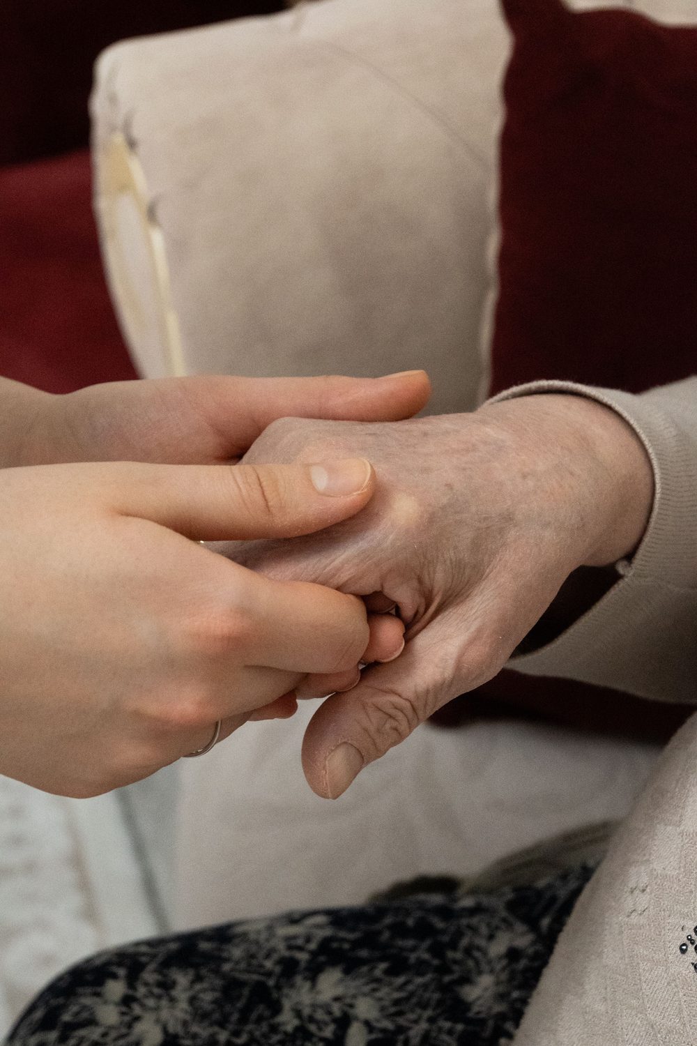 Zorgverlener houdt liefdevol de hand van een cliënt vast
